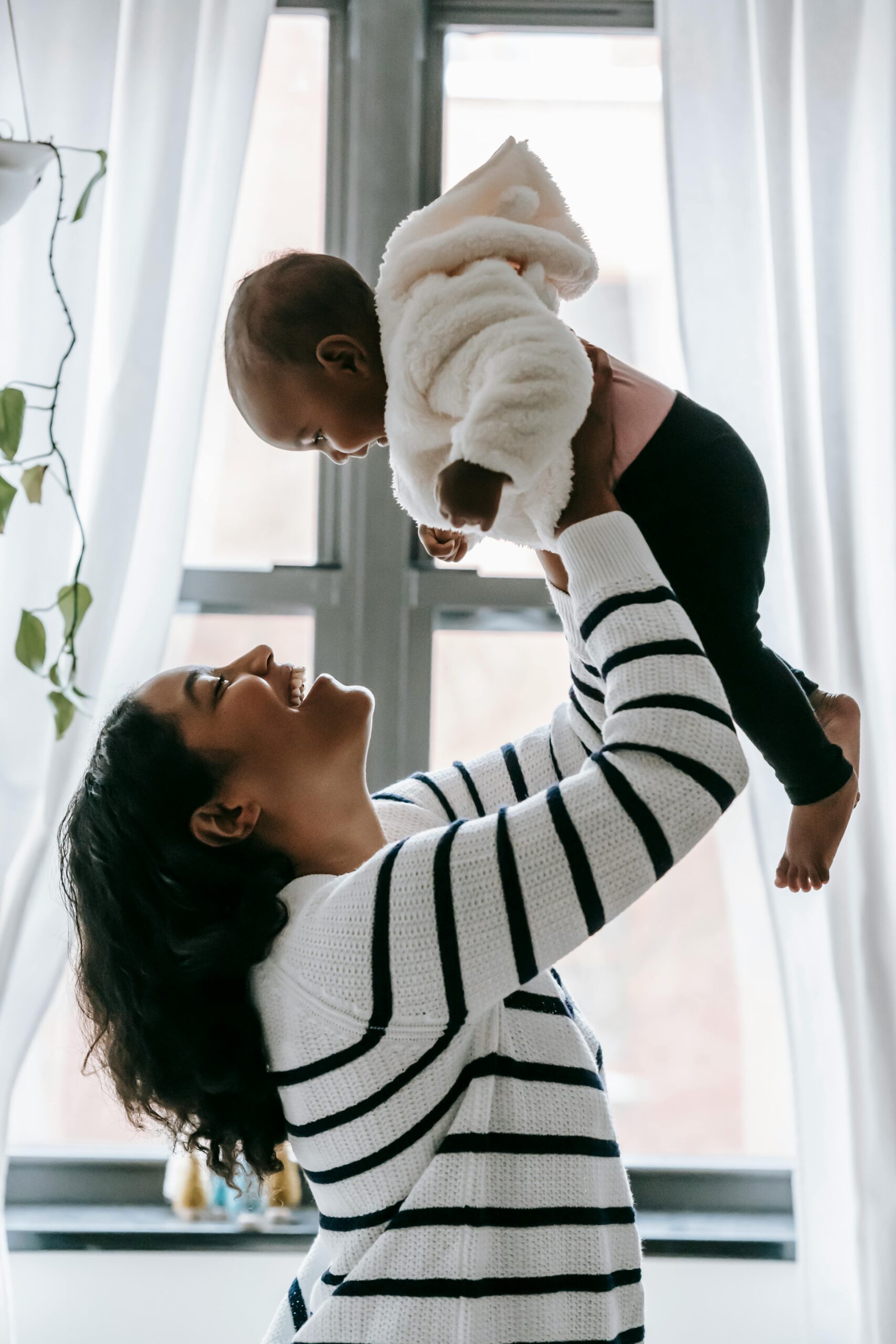 A mother holding her baby up high A mother holding her baby up high